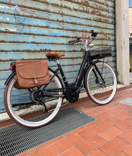 Bici elettrica nera Esposto Cicli davanti a una saracinesca a Senigallia