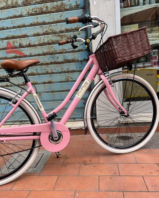 Bici da città rosa Via Veneto davanti a una saracinesca